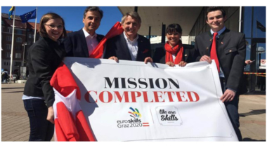 five people holding a mission completed sign