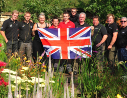 People holding a union jack in a garden