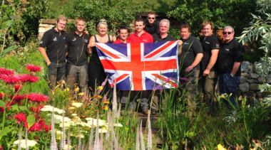 People holding a union jack in a garden