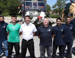 Group of people infront of helicopters