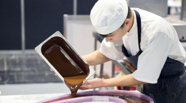 Photo of Ben pouring chocolate into a mould in patisserie and confectionery competition