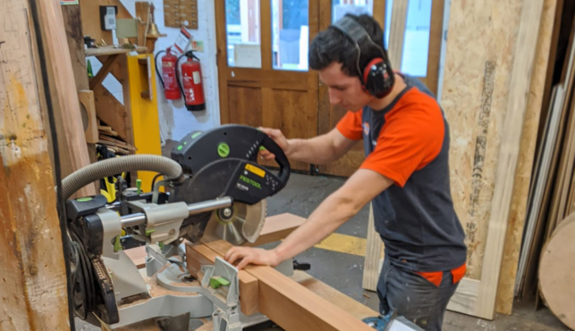 Photo of Ross sawing wood in joinery