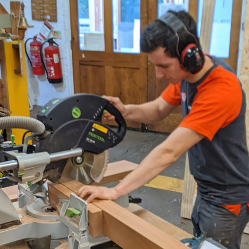 Photo of Ross sawing wood in joinery
