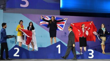 Photo of competitors carrying UK flags on stage at WorldSkills Abu Dhabi 2017