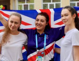 Photo of 3 members of Team UK holding flag at Kazan 2019