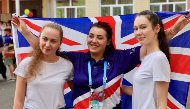 Photo of 3 members of Team UK holding flag at Kazan 2019