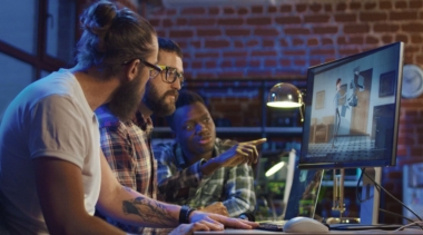 Photo of animators looking at computer screen animation