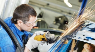 Photo of automotive body repair using machine on outside of car frame