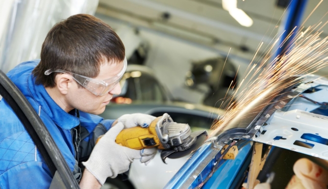 Photo of automotive body repair using machine on outside of car frame