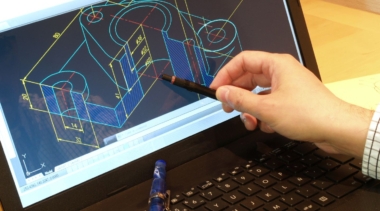 Photo of a CAD Technician pointing at a drawing on a computer screen