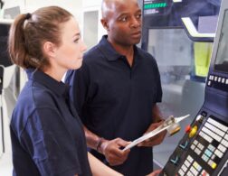 Photo of CNC Machinist looking at CNC machine