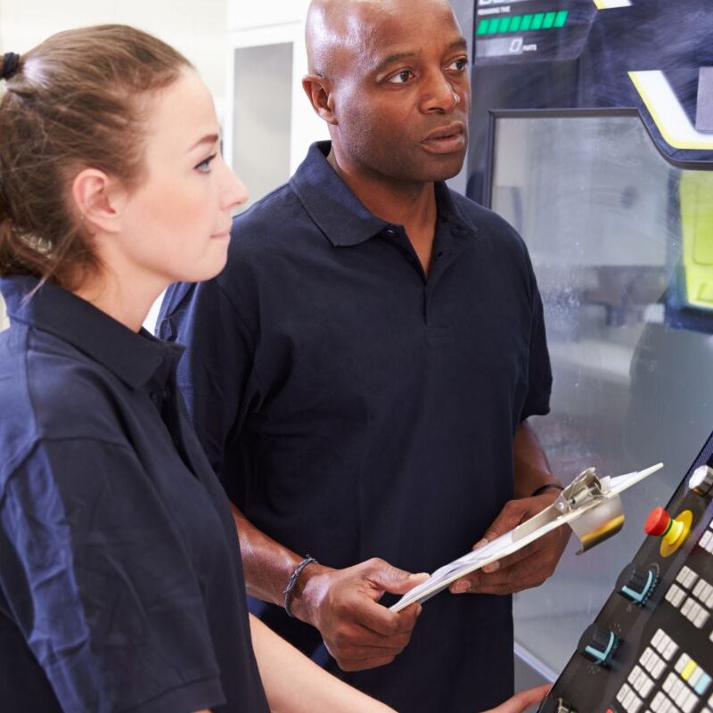 Photo of CNC Machinist looking at CNC machine