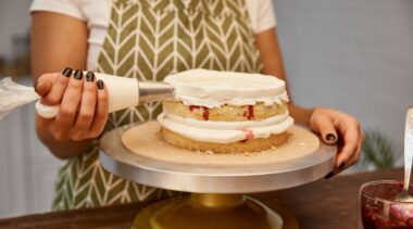 Photo of confectionery chef icing a cake