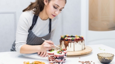 Photo of a confectionery chef placing decoration on top of dessert cups