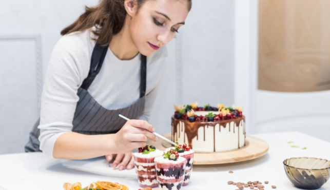 Photo of a confectionery chef placing decoration on top of dessert cups