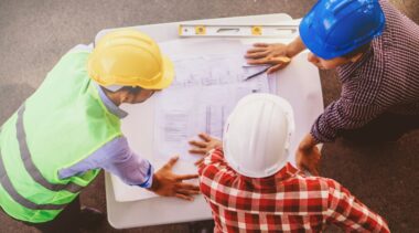 Photo of construction project managers examining drawings