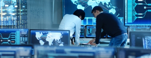 Photo of two cyber intelligence officers in a control room with lots of computer screens