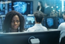 Photo of a cyber intelligence officer in a control room with lots of computer screens