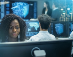 Photo of a cyber intelligence officer in a control room with lots of computer screens