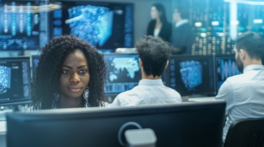 Photo of a cyber intelligence officer in a control room with lots of computer screens