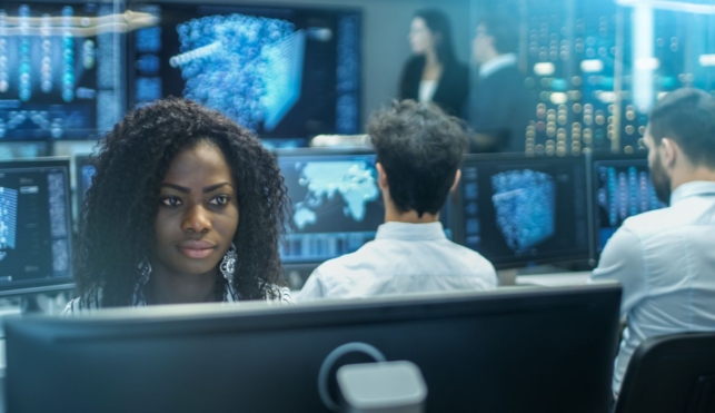 Photo of a cyber intelligence officer in a control room with lots of computer screens