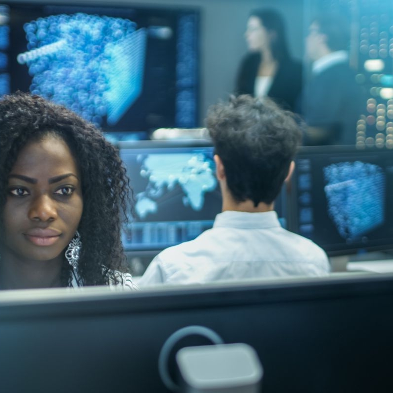 Photo of a cyber intelligence officer in a control room with lots of computer screens