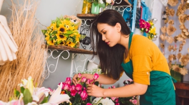 Photo of florist arranging a bunch of pink flowers