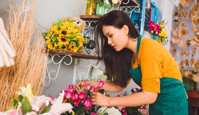 Photo of florist arranging a bunch of pink flowers