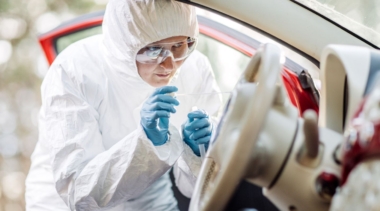 Photo of forensic scientist collecting swab evidence from a car steering wheel