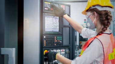 Photo of industrial control technician examining machine display