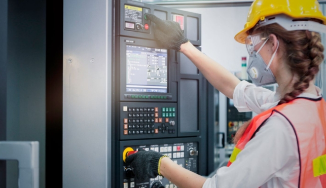 Photo of industrial control technician examining machine display