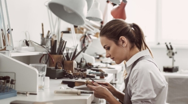 Photo of jewellery working on a piece of jewellery in a workshop