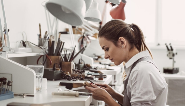 Photo of jewellery working on a piece of jewellery in a workshop