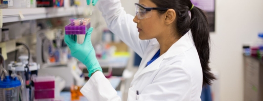 Photo of young lab technician inserting pipette into tray holder