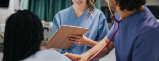 Photo of nurse with patient writing on clipboard