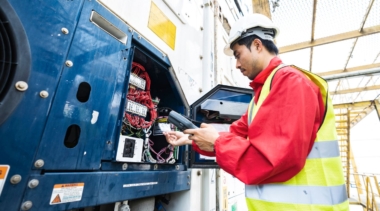 Photo of a young refrigeration engineer examining equipment