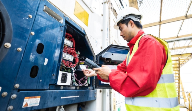 Photo of a young refrigeration engineer examining equipment