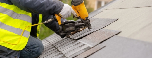 Photo of roofer nailing tiles to a roof