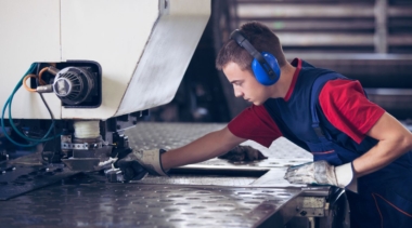 Photo of a young male sheet metalworker using a large machine