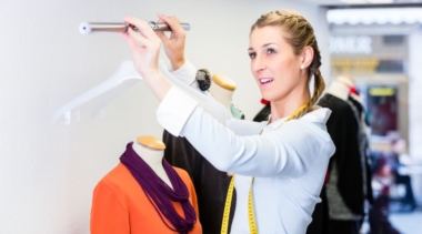 Photo of a Visual Merchandiser adjusting a clothes rail with hangers