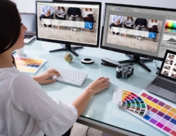 Photo of a young web designer with multiple computer screens