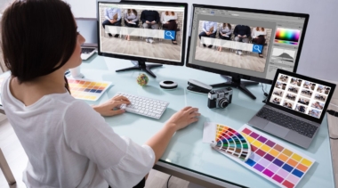 Photo of a young web designer with multiple computer screens