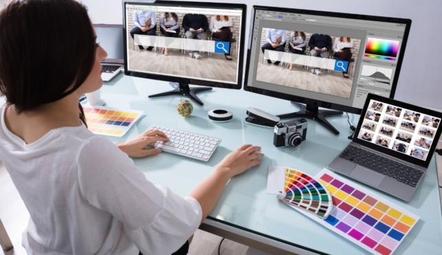 Photo of a young web designer with multiple computer screens