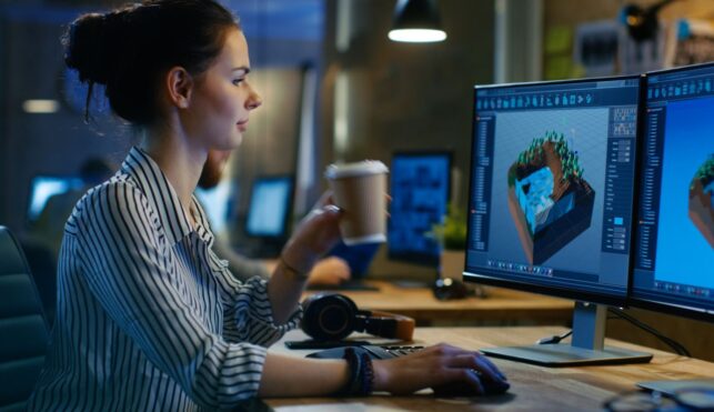 Photo of animator looking at computer screen with animations