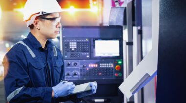 Photo of industrial control technician examining machine