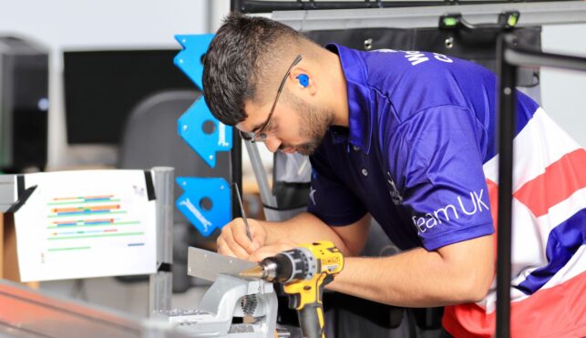 Photo of Isaac competing internationally in the Manufacturing Team Challenge