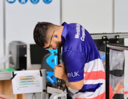 Photo of Isaac competing internationally in the Manufacturing Team Challenge