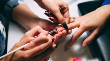 Photo of nail technician close up painting nails