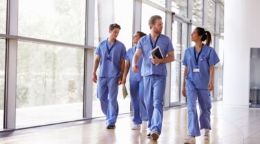 Photo of nurses walking down hospital corridor in blue scrubs