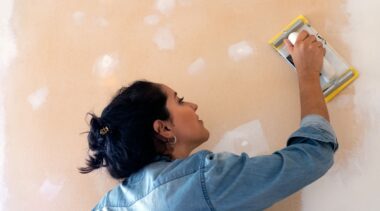 Photo of plasterer smoothing wall